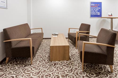 three chairs and a table in a waiting room at Holiday Inn Express Nürnberg-Schwabach in Schwabach