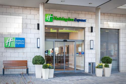 a store front with a bench in front of a building at Holiday Inn Express Nürnberg-Schwabach in Schwabach