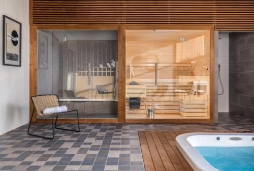 um quarto com uma banheira e uma cadeira ao lado de um quarto com uma cama em Papafigo Camping em Vodnjan