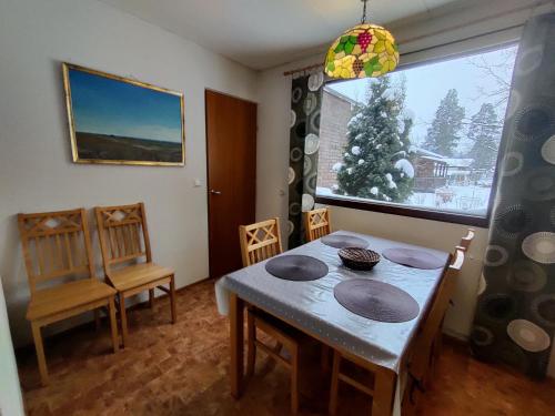 uma sala de jantar com mesa e cadeiras e uma árvore de Natal em Villa Campari em Imatra