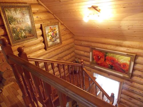a staircase in a log cabin with paintings on the wall at Pumpuri in Svente