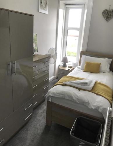 a bedroom with a bed and a dresser and a window at Teviot View Holiday Let’s Hawick in Hawick