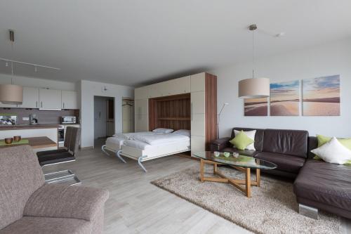 a living room with a bed and a couch at Christiansen im Panoramahaus Duhnen in Cuxhaven