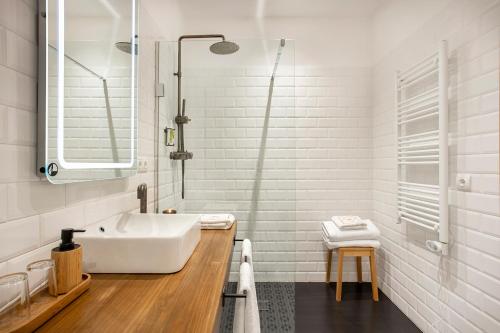 ein weißes Badezimmer mit einer Badewanne und einem Waschbecken in der Unterkunft Cal Roure Boutique Hotel in Igualada