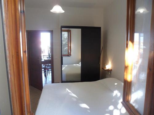 a bedroom with a white bed and a mirror at Da Elisa in Chiessi