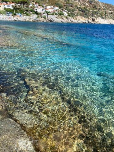 a large body of water with a beach and rocks at Da Elisa in Chiessi