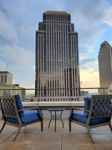 two chairs and a table on a balcony with buildings at NOPSI Hotel New Orleans in New Orleans
