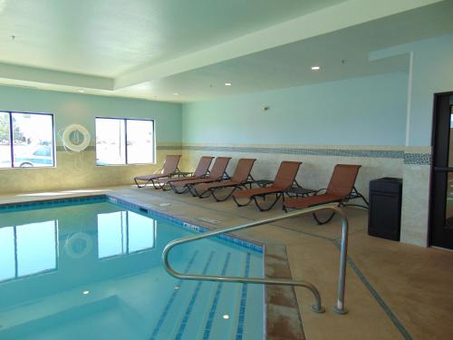 a swimming pool with chairs in a room at Holiday Inn Express & Suites Springville-South Provo Area, an IHG Hotel in Springville