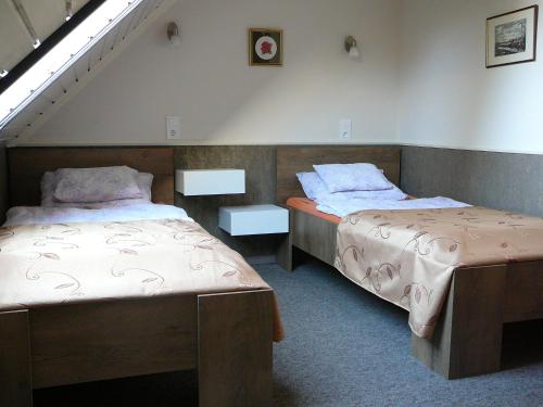 1 dormitorio con 2 camas y escalera en Dunakanyar Apartment, en Tahitótfalu