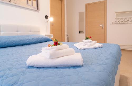 a blue bed with towels on top of it at South Valley in Agrigento