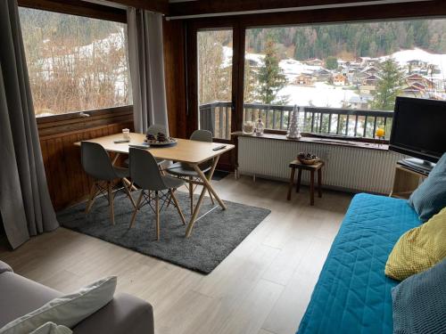 een woonkamer met een tafel en stoelen en een groot raam bij Le Bionnassay in Les Contamines-Montjoie