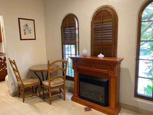 a living room with a fireplace and a table and chairs at Villa Rosa Inn in Santa Barbara