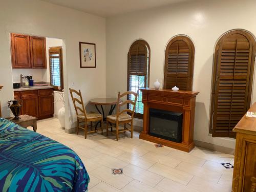 a bedroom with a bed and a table with a fireplace at Villa Rosa Inn in Santa Barbara