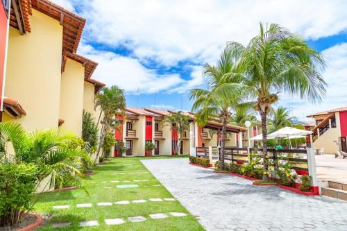 einen Innenhof eines Resorts mit Palmen in der Unterkunft Casa Duplex 3 suítes em Condomínio Fechado in Porto Seguro