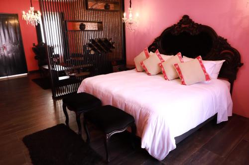 a bedroom with a large white bed with pink walls at Casa Rosa Hotel & Spa in San Cristóbal de Las Casas