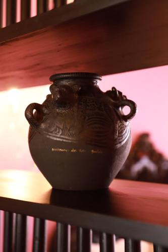 a black vase sitting on top of a shelf at Casa Rosa Hotel & Spa in San Cristóbal de Las Casas
