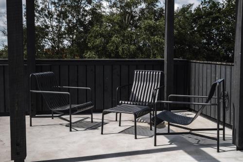 a group of chairs and a table on a patio at OTTO Hotel & Sun in Pāvilosta