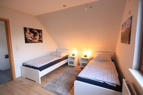 two beds in a small room with two lamps at WEIßE HÖHEN -Ferienhaus, Dibbersen bei Hamburg in Buchholz in der Nordheide