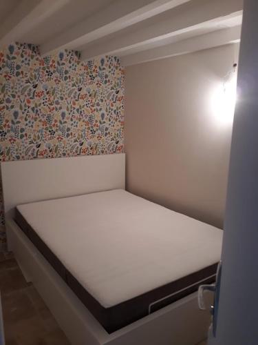 - une petite chambre avec un lit blanc et un mur dans l'établissement Studio