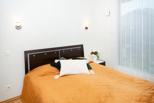 1 dormitorio con 1 cama grande con colcha de color naranja en Küüni 5b Guest Apartment en Tartu