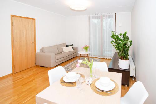 a living room with a white table and chairs at Küüni 5b Guest Apartment in Tartu