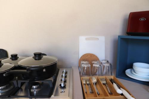 a kitchen with a stove with a pot and utensils at Gran Despertar El Faro Hotel in Santiaguillo
