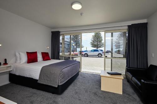 
a bedroom with a large bed and a large window at The White Morph - Heritage Collection in Kaikoura
