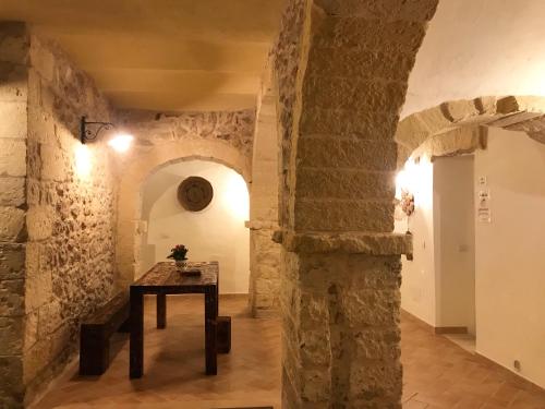 a hallway with stone walls and a table in a room at Domo Antiga Guest Rooms in Sorso