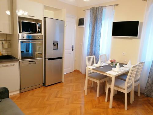 kuchnia i jadalnia ze stołem i krzesłami w obiekcie APARTMAN LUŠETIĆ w mieście Opatija