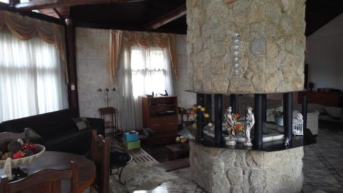a living room with a stone fire place at Pousada Sitieto Voitov in Aluminio