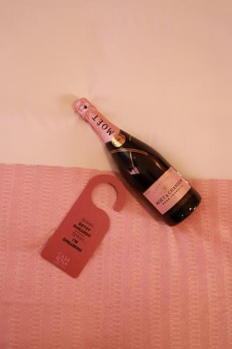 a bottle of wine with a tag on a bed at Casa Rosa Hotel & Spa in San Cristóbal de Las Casas