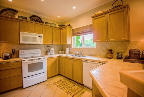 a kitchen with wooden cabinets and a white stove top oven at HRG Condos at Los Sueños in Jacó