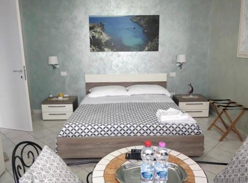 - une chambre avec un lit et une table avec des bouteilles d'eau dans l'établissement Belvedere, à Castro di Lecce
