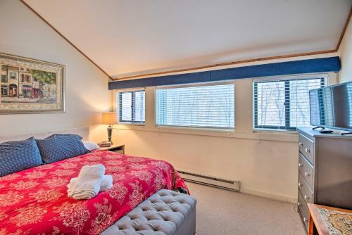 a bedroom with a bed and a tv and windows at Loon Mountain Condo with Pool and Game Room Access! in Lincoln