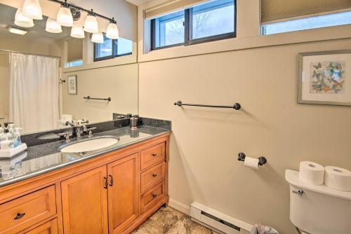 a bathroom with a sink and a mirror and a toilet at Loon Mountain Condo with Pool and Game Room Access! in Lincoln