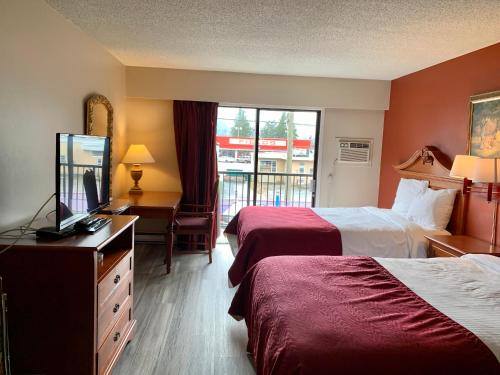 a hotel room with two beds and a flat screen tv at Windsor Motel in Hope