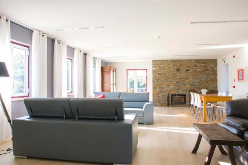 a living room with couches and a table and chairs at Monte Corgo da Vaca in Sabóia