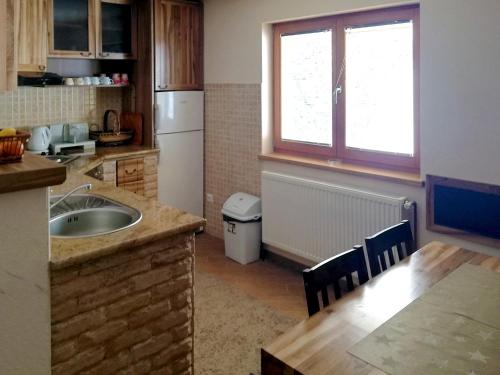 a kitchen with a sink and a table and a refrigerator at Villa Franka - Vlašić in Vlasic