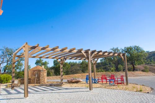a group of red chairs under a wooden pergola at Monte Corgo da Vaca in Sabóia