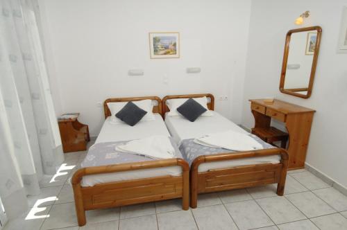 a bedroom with two twin beds and a mirror at Alexis Studios and Apartments in Agia Effimia