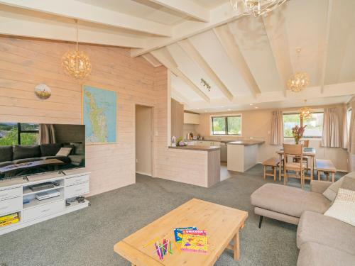 a living room with a couch and a table at Daze Away - Cooks Beach Holiday Home in Cooks Beach