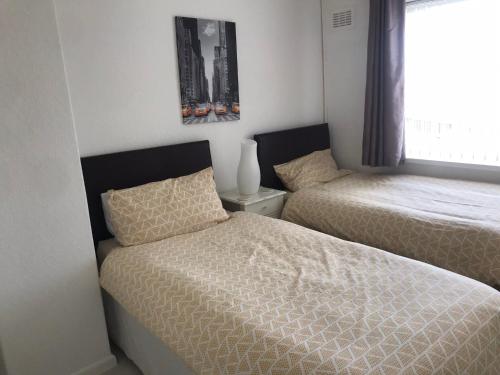 een slaapkamer met 2 bedden naast een raam bij Diana House - Great location in Coventry