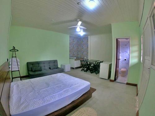 een slaapkamer met een bed, een bank en een tafel bij Kitnet Com Ar, em frente a Praia de Boracéia in Sao Paulo