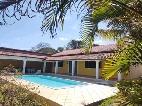uma casa com uma piscina em frente em Pousada chácara amarela - Analandia SP em Analândia