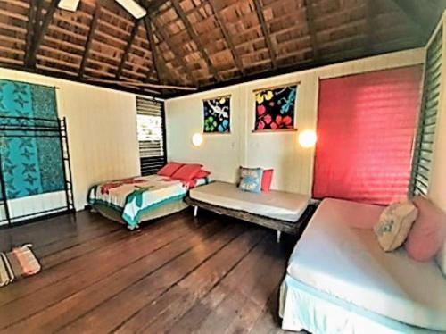 a bedroom with two beds and a wooden floor at MOOREA - Local Spirit Iti 2 in Hauru