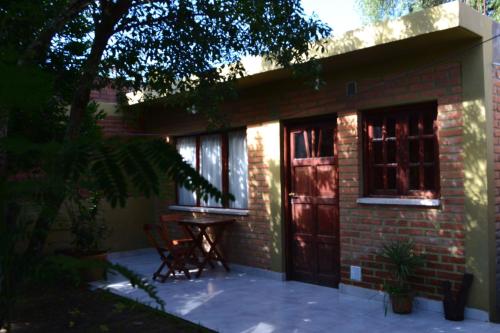 a small brick house with a table and two windows at Posada Rivera in San Salvador de Jujuy