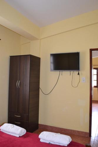 a bedroom with a flat screen tv on the wall at Posada Rivera in San Salvador de Jujuy