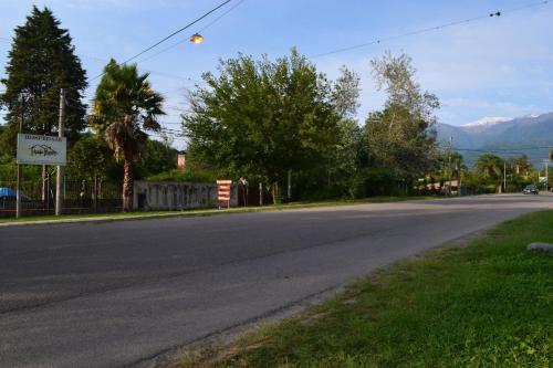 an empty street with trees and mountains in the background at Posada Rivera in San Salvador de Jujuy
