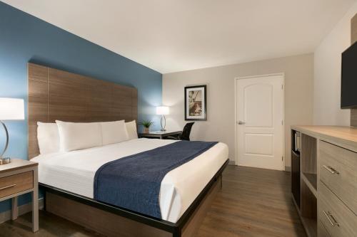 a hotel room with a large bed and a desk at Torch Lite Inn at the Beach Boardwalk in Santa Cruz