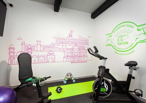 a gym with two exercise bikes and a wall mural at Hotel MX zócalo CDMX, Trademark Collection by Wyndham in Mexico City